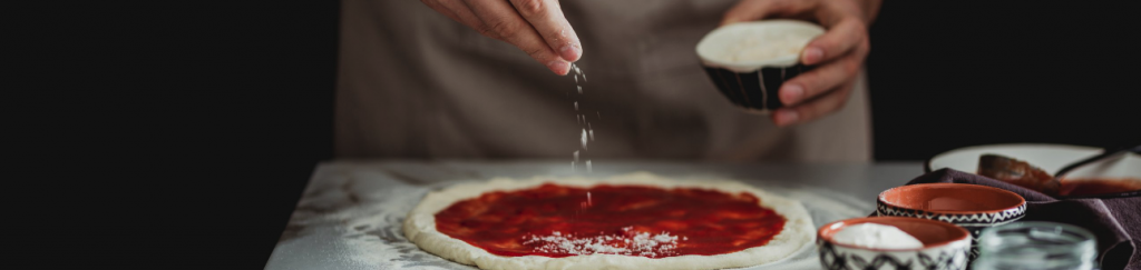 Sprinkling cheese on pizza